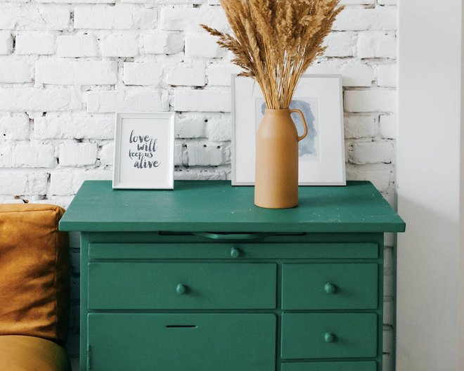 Neatly furnished room with a green wooden drawer in the middle