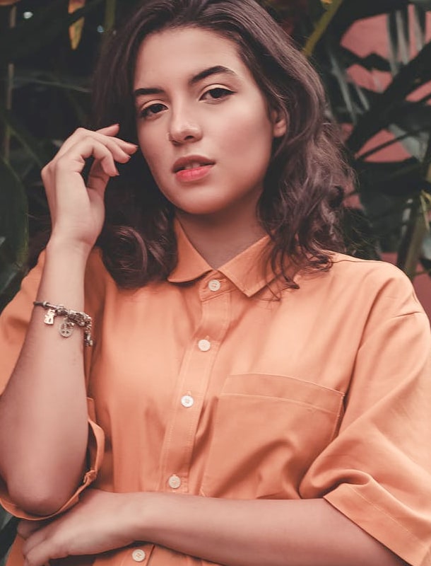 A fashionably-looking brunette in a pale red shirt