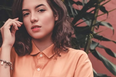 A fashionably-looking brunette in a pale red shirt