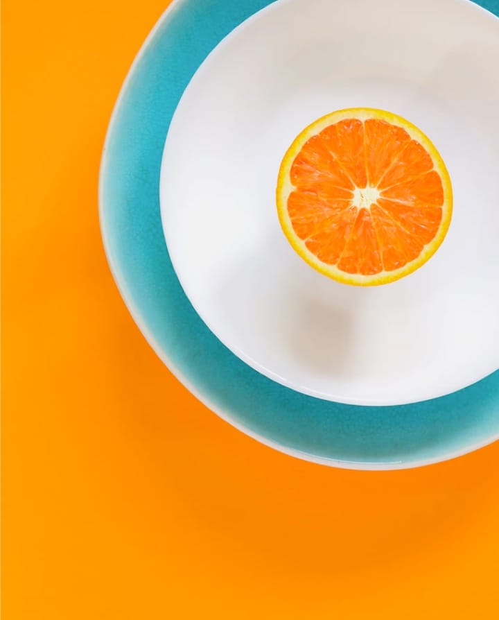 white place with blue borders on orange background with a slice of orange on it